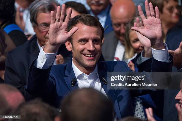 French Minister of Economic, Emmanuel Macron waves at the crowd as he arrives for the 'En Marche' political party meeting at Theatre de la Mutualite...