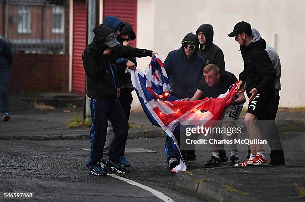 Nationalist youths burn a Union Jack flag at Ardoyne after the annual Orange march on July 12, 2016 in Belfast, Northern Ireland. The controversial...