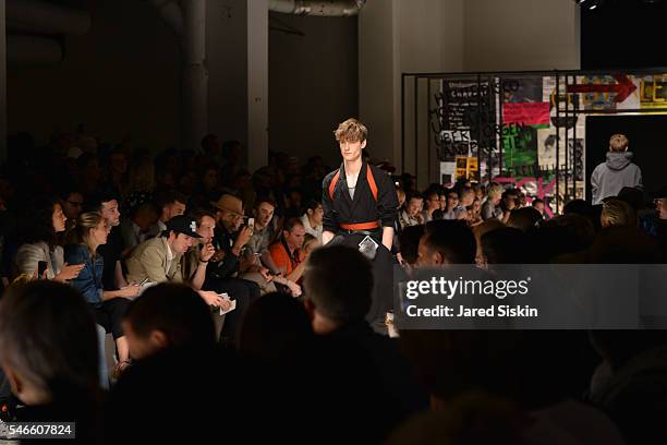 Model walks the runway of the Robert Geller show during New York Fashion Week: Men's S/S 2017 at Skylight Clarkson Square on July 12, 2016 in New...