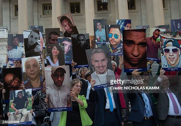 Members and supporters of the US Congressional LGBT Equality Caucus hold pictures of victims of the Pulse nightclub attack, one month after a gunman...