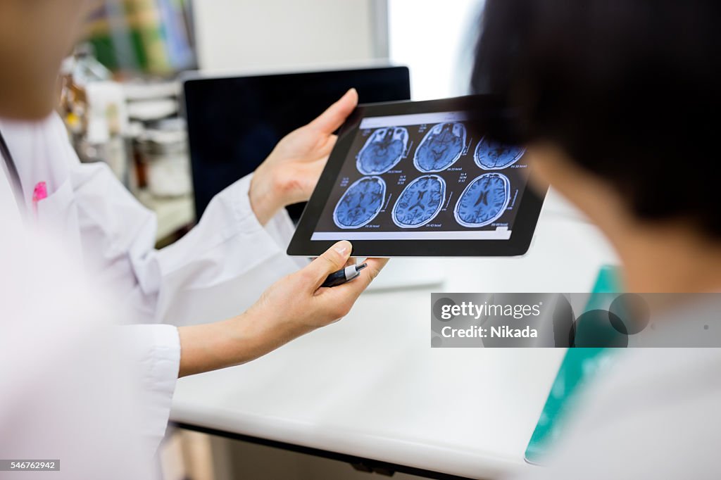 Doctor and patient using digital tablet in hospital