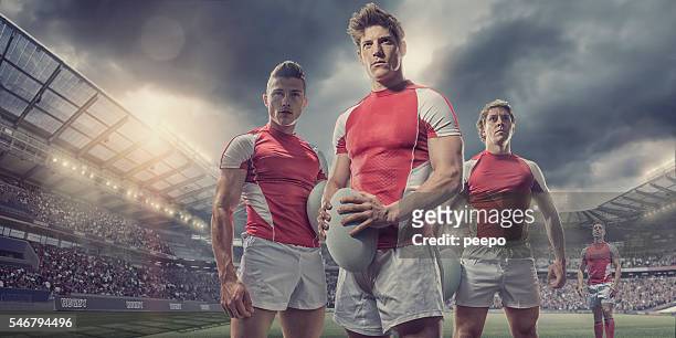 heroicos jugadores de rugby de pie con pelota en el campo en el estadio - rugby union fotografías e imágenes de stock