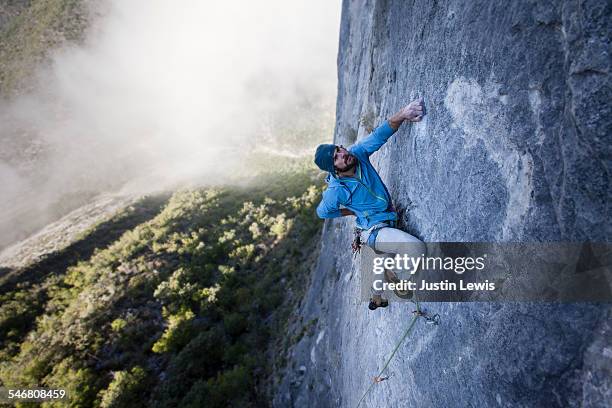 solo guy climbs rock wall - scalata foto e immagini stock