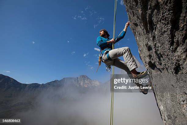 solo man ascends rock face - wonderlust2015 stock pictures, royalty-free photos & images