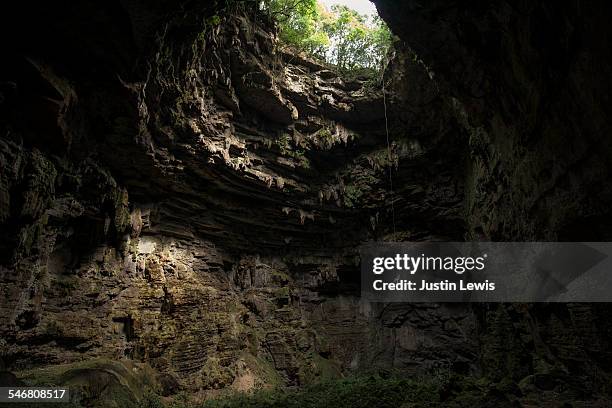 man rappels into ancient cave - wonderlust2015 stock pictures, royalty-free photos & images