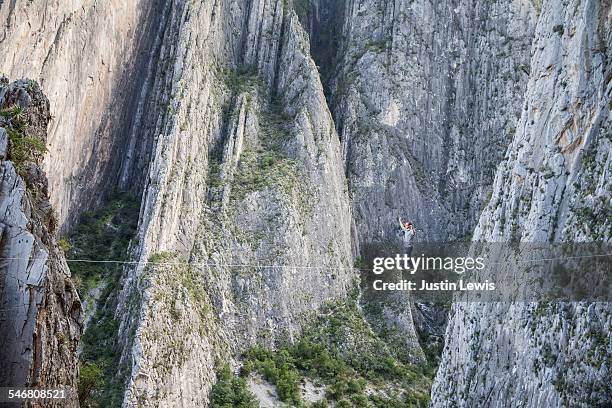 man crosses canyon on high line - wonderlust2015 stock pictures, royalty-free photos & images