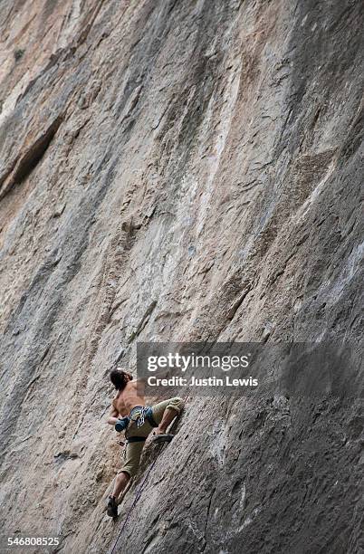 climber scales vertical rock wall - wonderlust2015 stock pictures, royalty-free photos & images