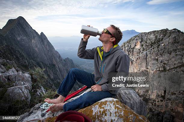 man rests on mountain rocks, drinking - wonderlust2015 stock pictures, royalty-free photos & images
