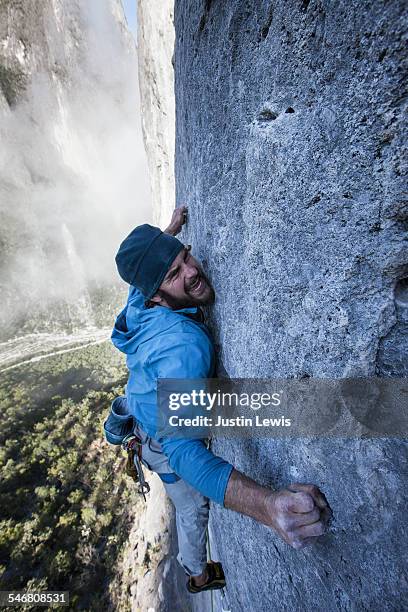 man barely hangs on rock wall - wonderlust2015 stock pictures, royalty-free photos & images
