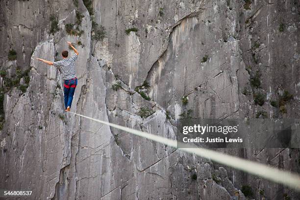 man crosses abyss on rope - wonderlust2015 stock pictures, royalty-free photos & images