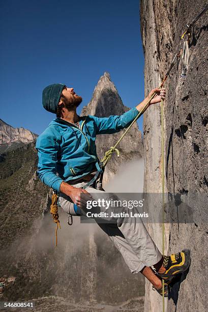 man ascends steep rock wall - wonderlust2015 stock pictures, royalty-free photos & images
