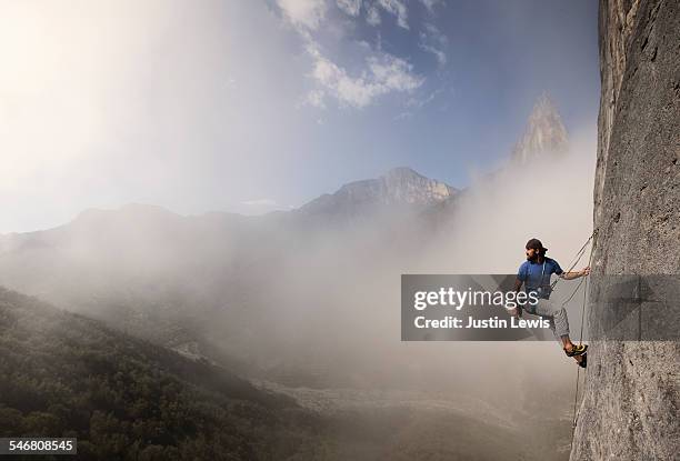 solo man climbs rock wall - clambering stock pictures, royalty-free photos & images