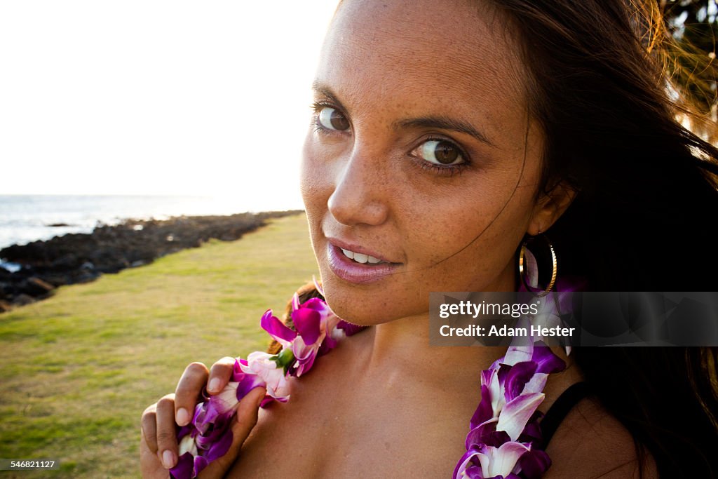 Caucasian woman wearing flower lei near ocean