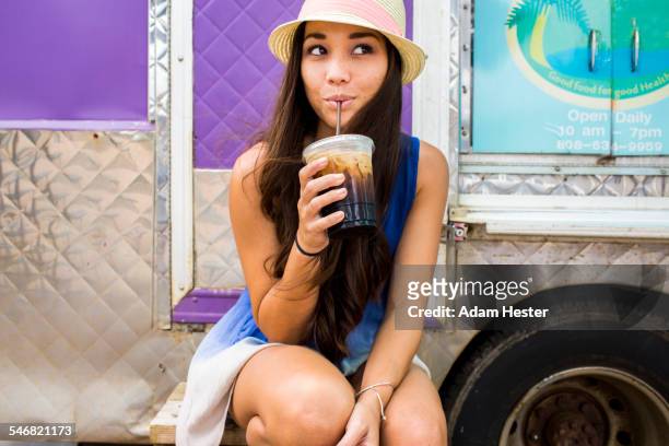 woman drinking ice coffee near food cart - coffee drink stock pictures, royalty-free photos & images