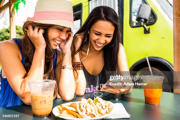 pacific islander women using cell phone near food cart - mexican food stock pictures, royalty-free photos & images