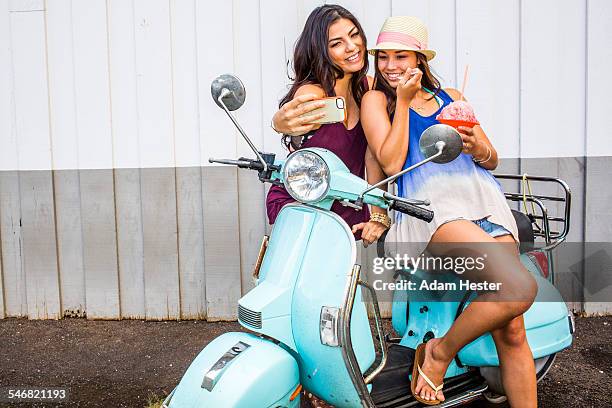 pacific islander women taking cell phone photograph on scooter - shaved ice stockfoto's en -beelden