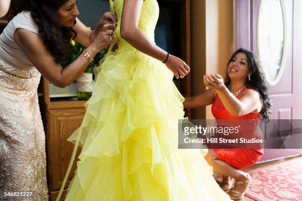 hispanic women adjusting quinceanera dress in living room - godparent stock pictures, royalty-free photos & images