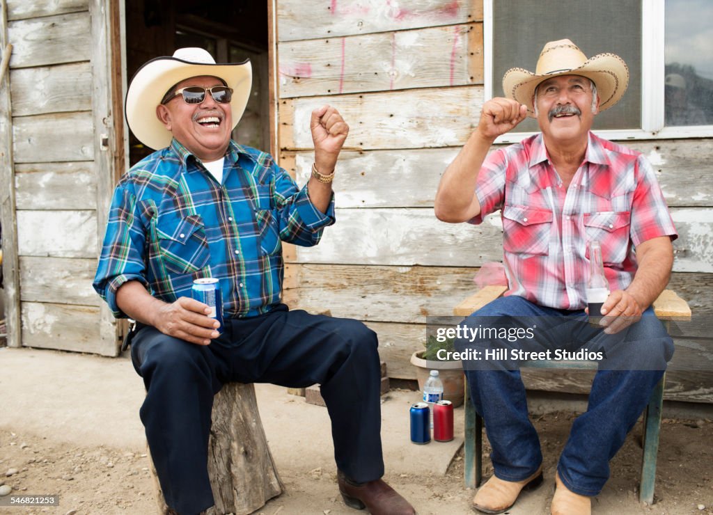 Hispanic men wearing cowboy hats cheering