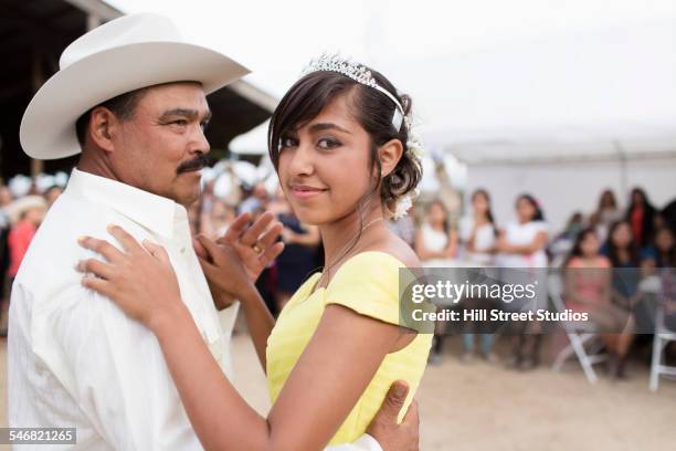 Hispanic father and daughter dancing at quinceanera