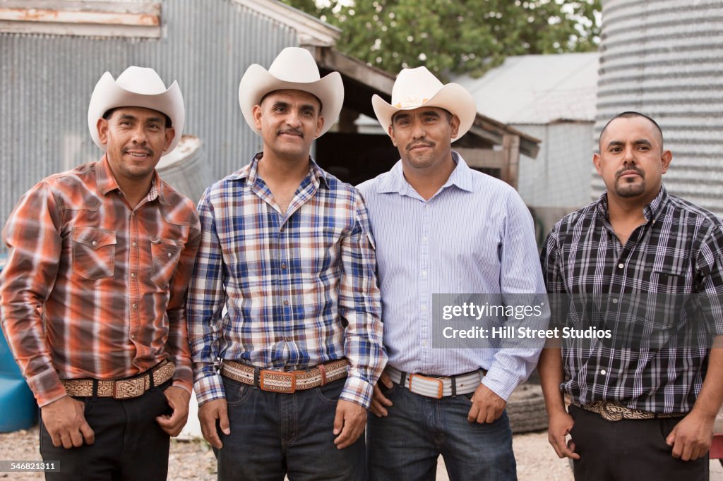 Hispanic men wearing cowboy hats on ranch