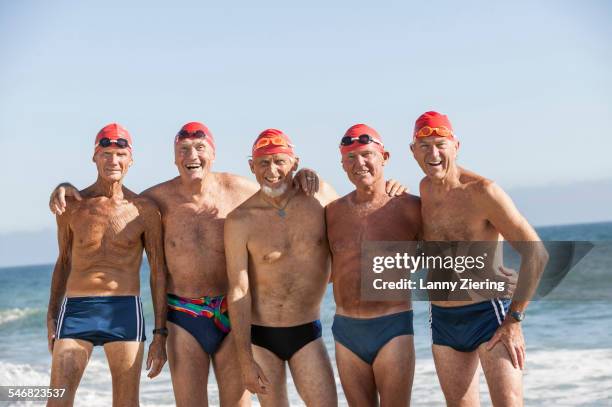 older men on swimming team smiling on beach - five people fotografías e imágenes de stock