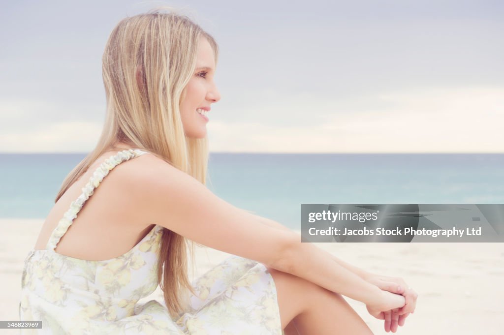 Caucasian woman sitting on beach