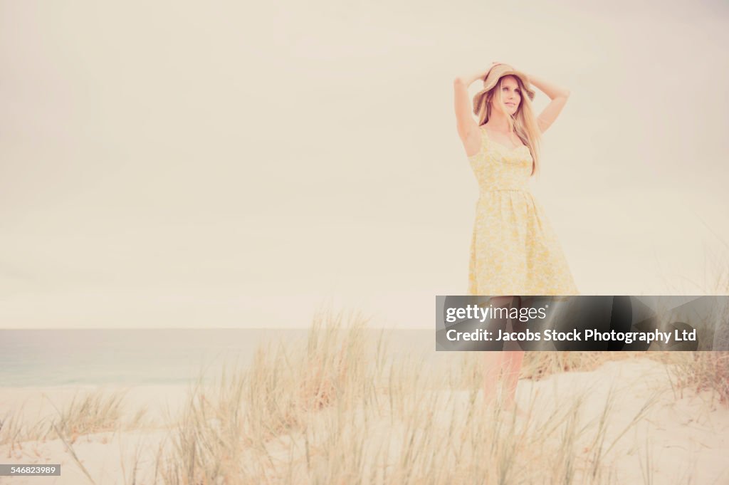 Caucasian woman walking on sand dune