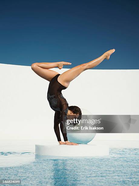 caucasian gymnast performing hand stand on ice floe - swimming pool and hand stock-fotos und bilder