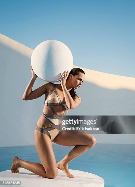 caucasian woman holding sphere on ice floe - atlas figura mitológica fotografías e imágenes de stock