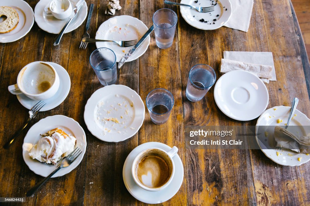 Empty plates, coffee cups and glasses on cafe table