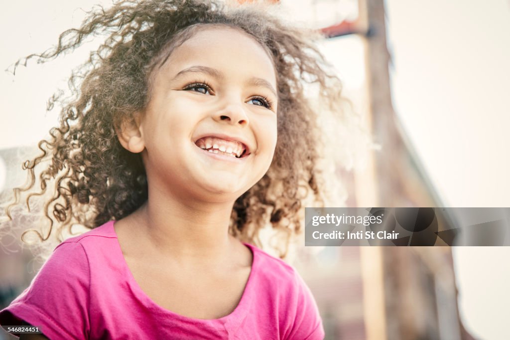 Low angle view of mixed race girl smiling outdoors