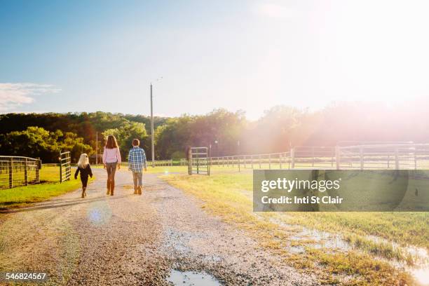 caucasian children walking on dirt road on ranch - 2014 track field stock pictures, royalty-free photos & images