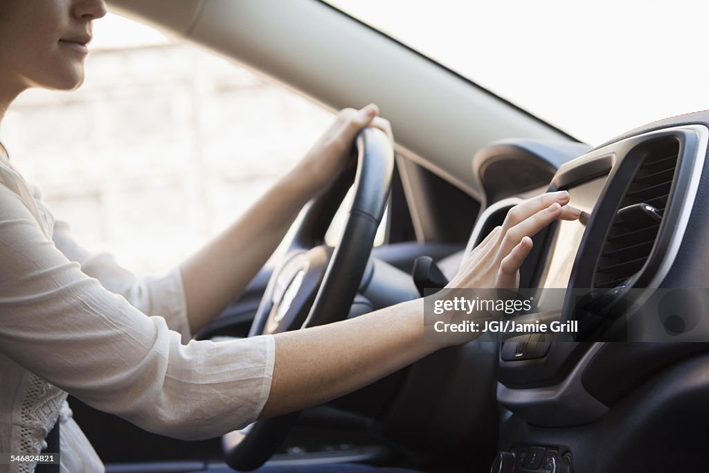 Caucasian woman using GPS system in car