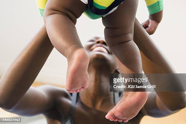close up of black mother playing with baby boy - black baby foto e immagini stock