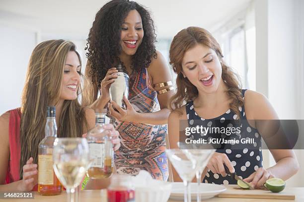 women making cocktails in kitchen - black people cocktail party stockfoto's en -beelden