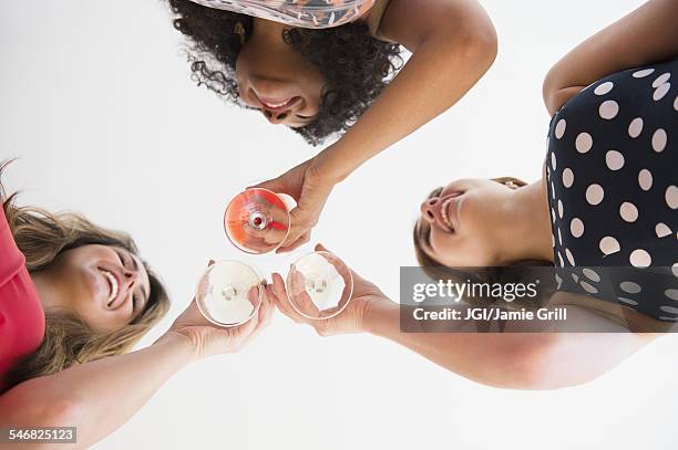 low angle view of women toasting with cocktails - low alcohol drink stock pictures, royalty-free photos & images