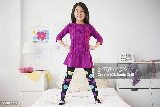 smiling vietnamese girl standing on bed - girl bedroom stock pictures, royalty-free photos & images