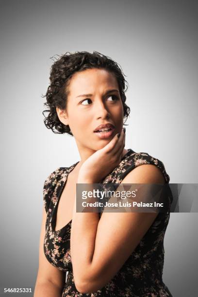 confused mixed race woman looking over her shoulder - person gemischter abstammung stock-fotos und bilder