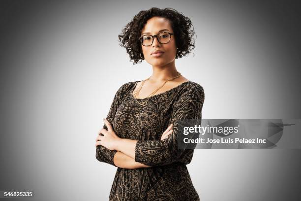 mixed race woman standing with arms crossed - mixed race woman stock-fotos und bilder