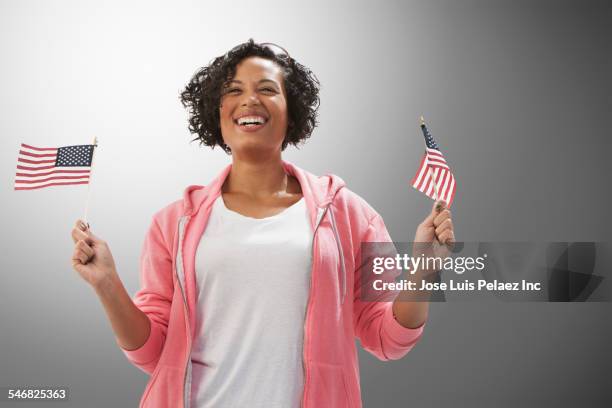 mixed race woman waving american flags - curly waves stock pictures, royalty-free photos & images