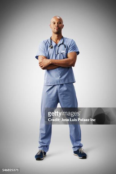 mixed race nurse standing with arms crossed - arms crossed stock pictures, royalty-free photos & images
