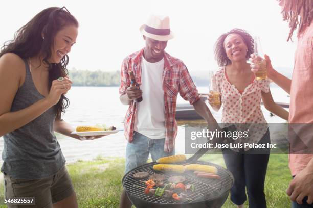friends grilling food at barbecue outdoors - bbq smoker stock pictures, royalty-free photos & images