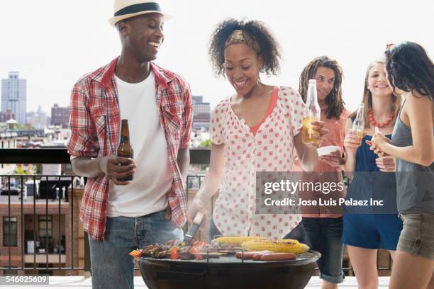 friends grilling food at barbecue outdoors - couple grilling stock pictures, royalty-free photos & images