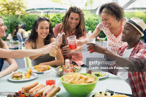 friends toasting each other at barbecue outdoors - asian eating hotdog stockfoto's en -beelden