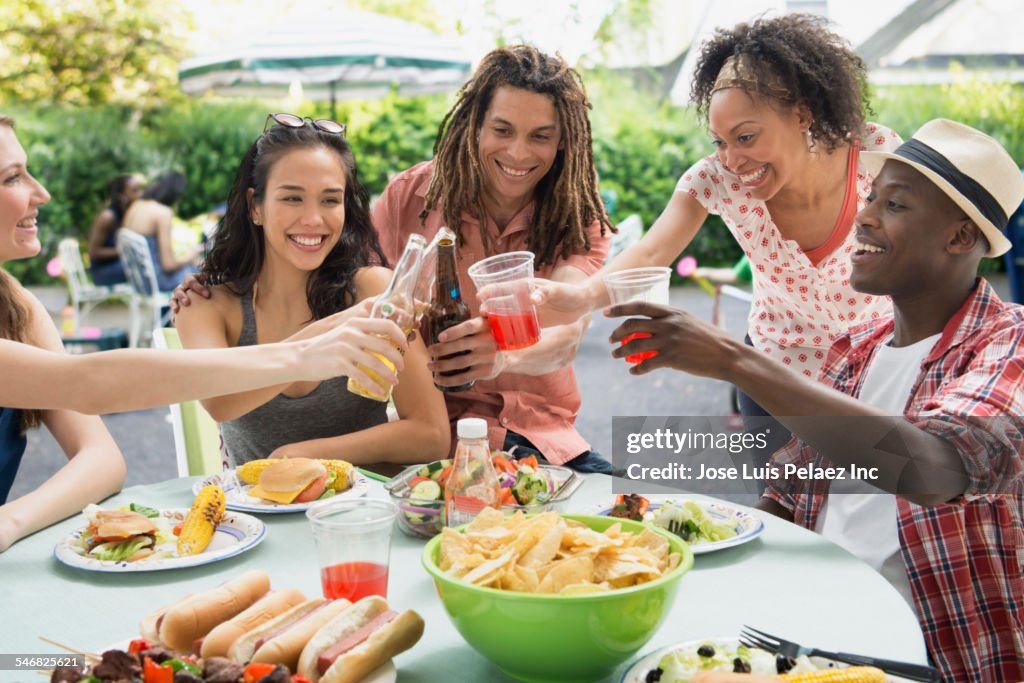 Friends toasting each other at barbecue outdoors