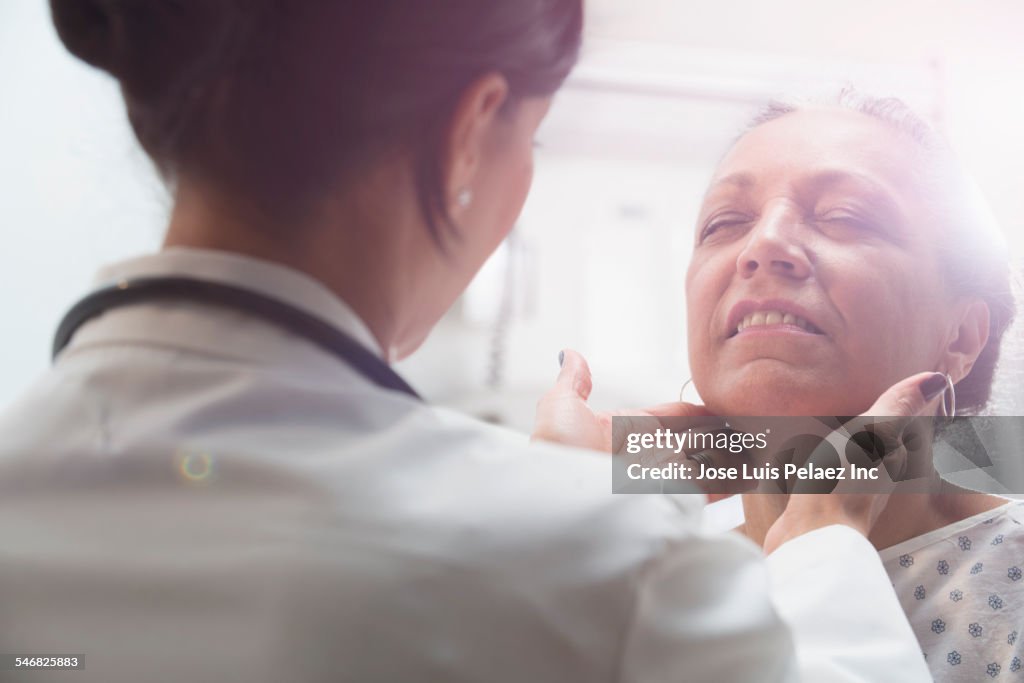 Hispanic doctor examining older patient