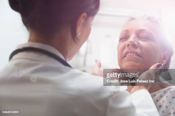 hispanic doctor examining older patient - examination closeup stock pictures, royalty-free photos & images