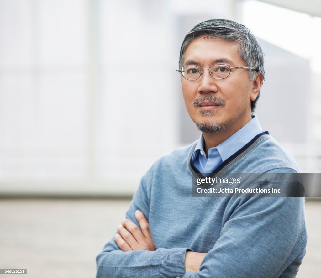 Pacific Islander businessman standing with arms crossed