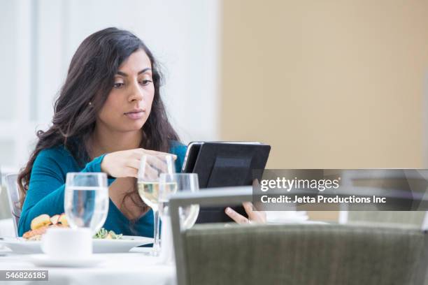 indian businesswoman using digital tablet at lunch - 2000 teleworking stock pictures, royalty-free photos & images