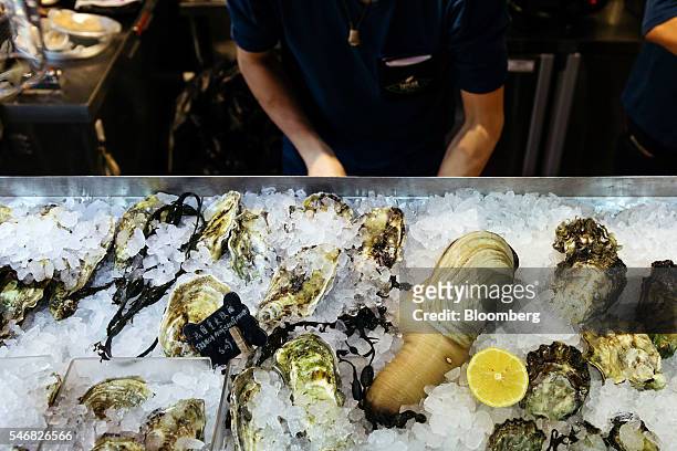 Geoduck and oysters are displayed on a bed of ice at the Taylor Shellfish Farms restaurant in the Sai Ying Pun area of Hong Kong, China, on Friday,...